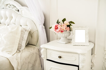 Photo frame with a white background in the interior of the bedroom. 