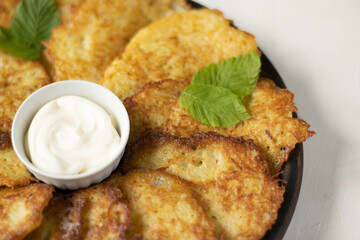 Fresh potato food, crispy pancakes fried on pan with garlic