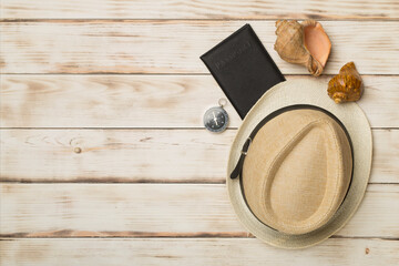 Hat, passport and seashells on color background, top view