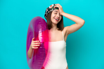 Young Ukrainian woman holding air mattress isolated on blue background has realized something and intending the solution