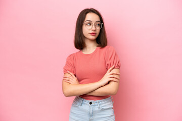 Fototapeta premium Young Ukrainian woman isolated on pink background keeping the arms crossed