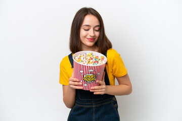 Young Ukrainian woman isolated on white background holding a big bucket of popcorns