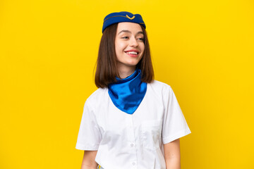 Airplane stewardess Ukrainian woman isolated on yellow background looking side