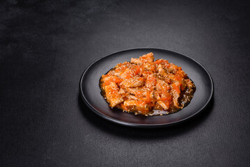 Teriyaki chicken with sauce, sesame, herbs and spices on a dark background