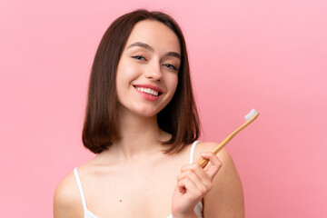 Young Ukrainian woman isolated on pink background with a toothbrush