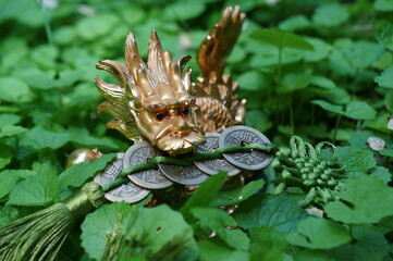 Fototapeta premium A dragon with a bunch of Chinese coins in his teeth. A symbol of power and achievement of the goal.