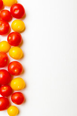 Red and yellow cherry tomatoes on white background. Top view. Copy space.