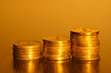A stack of coins on a golden background. Economics and finance.