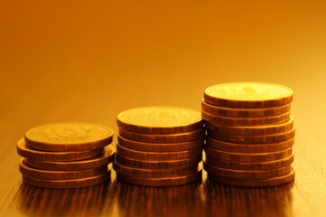 A stack of coins on a golden background. Economics and finance.