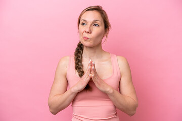 Young caucasian woman isolated on pink background scheming something