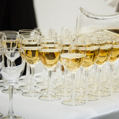 White wine pouring into a wine glass. Shallow depth of field.