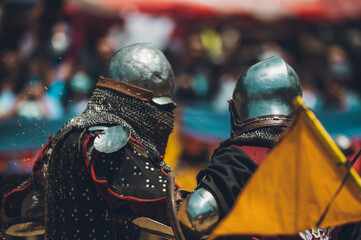 Pitch battle of medieval knights, using metal armor, axes, swords and shields to defend themselves.