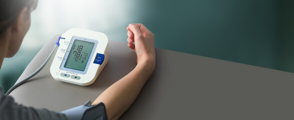 Young woman check blood pressure monitor and heart rate monitor with digital pressure gauge. Health care and Medical concept