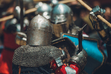 Fototapeta premium Pitch battle of medieval knights, using metal armor, axes, swords and shields to defend themselves.