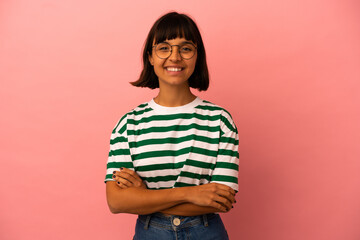 Young mixed race woman isolated on pink background keeping the arms crossed in frontal position