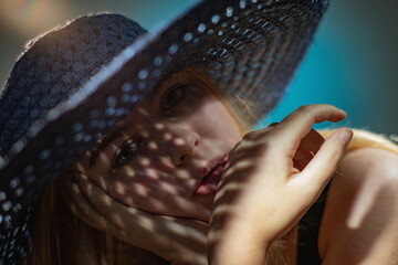 Portrait of a girl in a hat with a shadow on her face