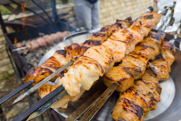 Grilled salmon fish kebab skewers on wooden board. Dark wooden background.