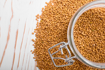 grains for brewing buckwheat tea in a jar on a white wooden background close-up from above