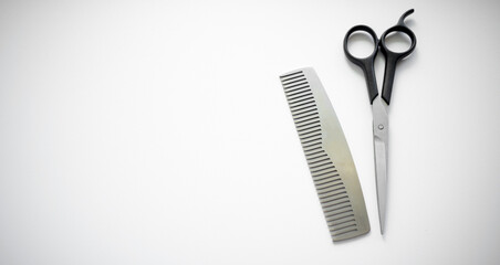 Hairdressing scissors with a comb on a white background.White isolate for the text of the hairdressing salon.A metal comb on the table.