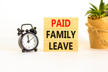 Paid family leave symbol. Concept words Paid family leave on wooden blocks. Black alarm clock. Beautiful white table white background. Business medical and paid family leave concept. Copy space.