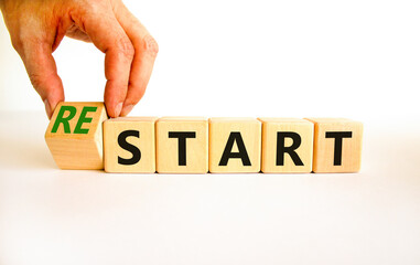 Start or restart symbol. Businessman turns wooden cubes and changes the concept word Start to...