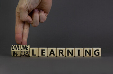 Online or in-class learning symbol. Businessman turns cubes, changes words online learning to...