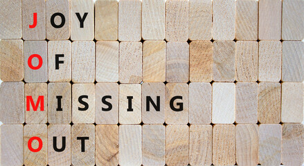 JOMO joy of missing out symbol. Concept words JOMO joy of missing out on wooden blocks on beautiful wooden background. Business JOMO joy of missing out concept. Copy space.