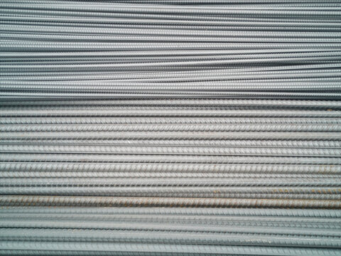 Closeup of concrete reinforcement steel rods in warehouse. Steel rods or bars used to reinforce concrete Steel rod. Construction steel. Ribbed iron bars waiting to be shaped and used for construction.