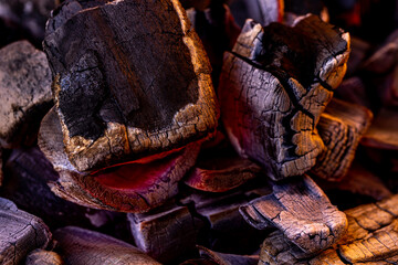 Glowing Hot Charcoal Background Texture. Red hot coals in the grill close up. hot red coals among black ash, wallpapers for mobile devices, abstract.
