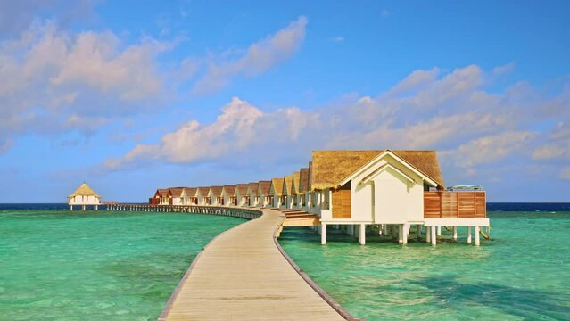 Boardwalk to overwater bungalow at a luxurious hotel resort in the Maldives with turquoise water
