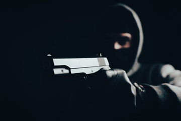 masked man holding a gun