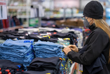 Pretty mature middle age woman shopping for clothes in a bright airy store.