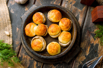 mushrooms baked with Suluguni cheese top view on wooden table