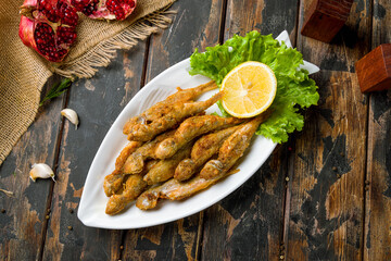 fried surmullet on plate on wooden board top view