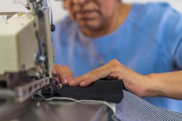 Close up of a mature latin woman using a sewing machine