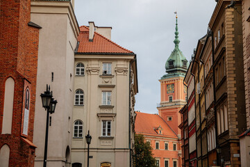Obraz premium Warsaw, Poland, 13 October 2021: Royal Castle with clock tower in old town, residence official home of Polish monarchs, fortified complex at sunny autumn day, Main square with Sigismund Column