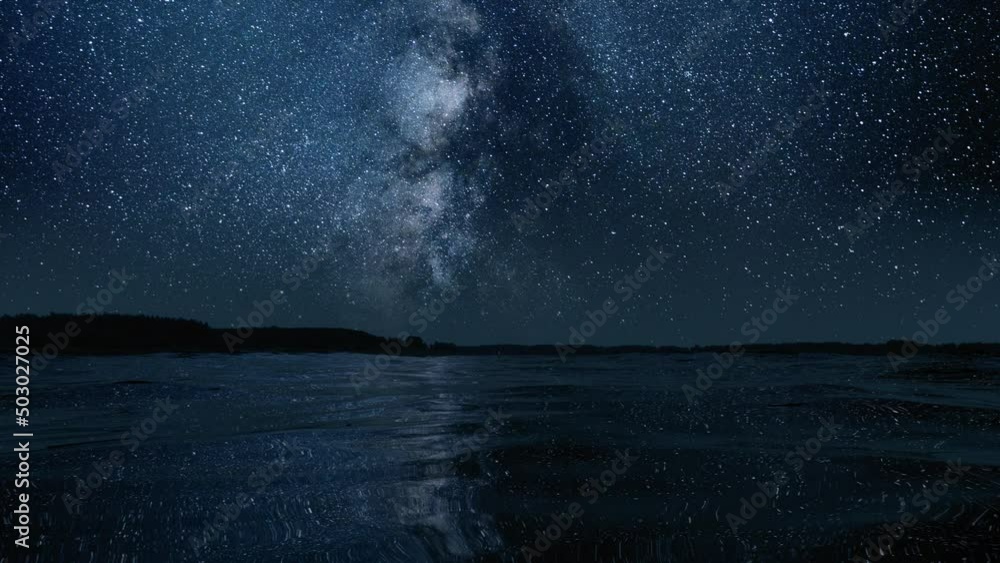 Wall mural the milky way is reflected in the waves of water, time-lapse