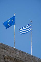 European and the Greece  flag against blue sky