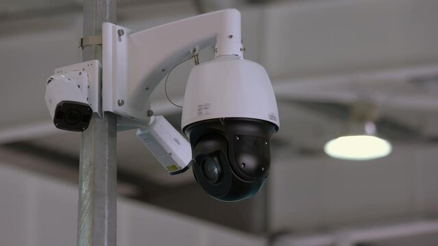 Close-up rotating black surveillance control camera indoors. Public safety concept.