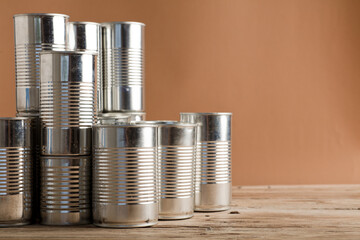 recycled cans, reused on a table with a brown background
top view, space for text.