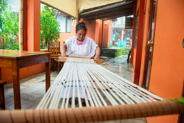 Mid adult native Mexican using a traditional loom 