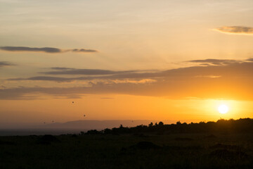 Fleet of Hot Air Balloons Floats Over the Maasai Mara, Kenya at Sunset	