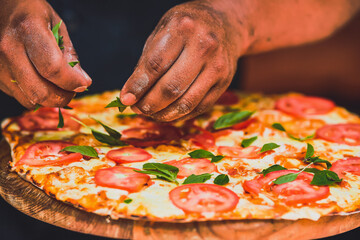 Latino man preparing artisanal pizza. Making pizza in a wood oven, vegan pizza, pizza amazon....