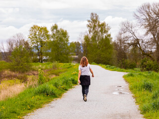 Woman walking in spring forest nature path walk on trail woods background. Woman relaxing on active outdoor activity.