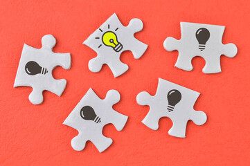 Jigsaw puzzle with light bulb symbols. Development of innovations and technologies. Creativity and ingenuity.