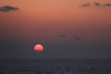 水平線と雲に沈む夕日
