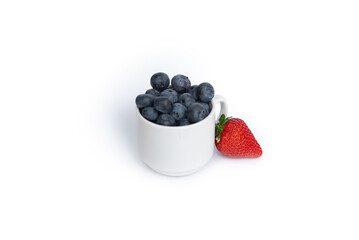 blueberries and strawberries in a small white cup on a white background in the center of the frame