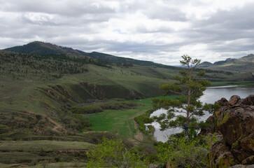 The valley of the river under an overcast cloudy sky. View of the river from a height.