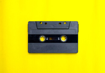 Old compact cassette tape on yellow background