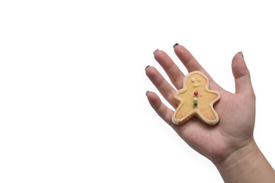 Woman Hand Holding Gingerbread Man Cookie Over White Background.